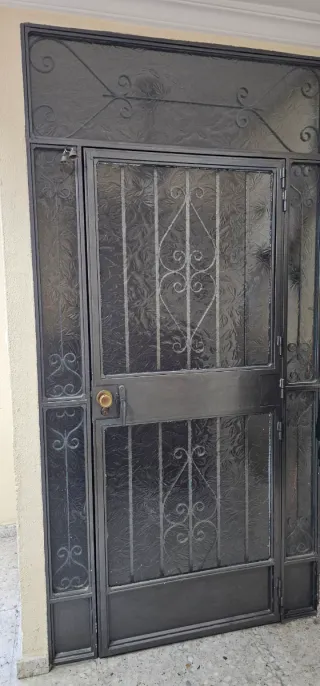 Puerta de entrada de forja con cristal