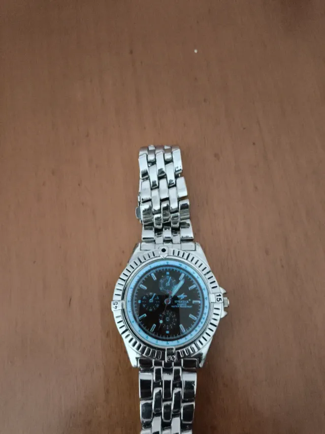 Reloj de pulsera plateado con esfera naranja