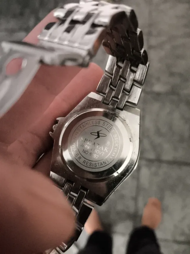 Reloj de pulsera plateado con esfera naranja