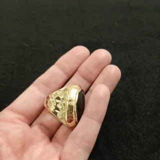 Anillo dorado con piedra negra