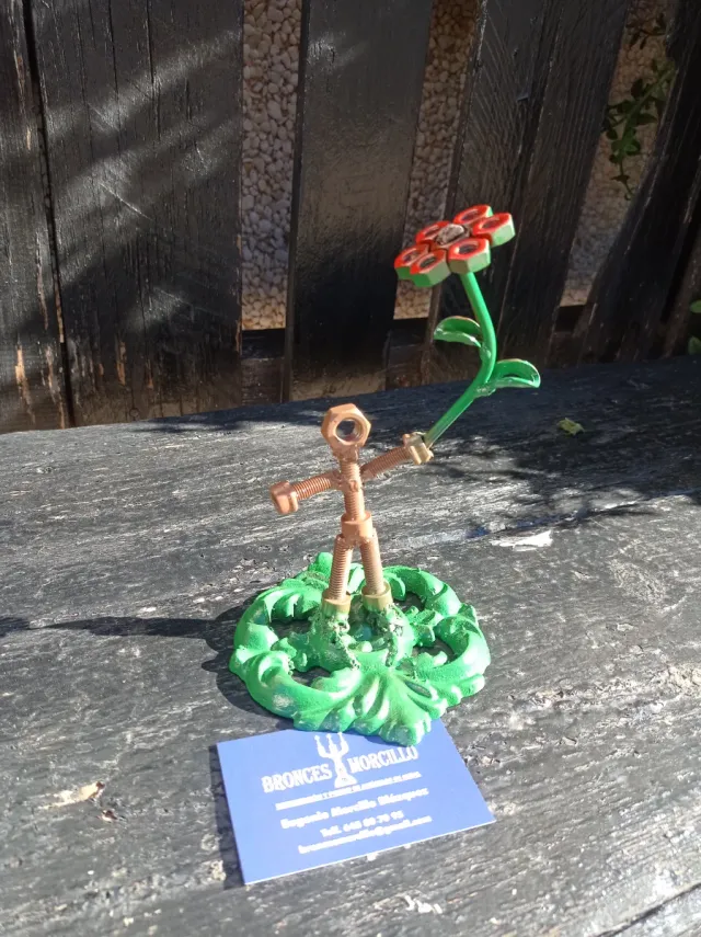 Escultura de metal: chico con flor