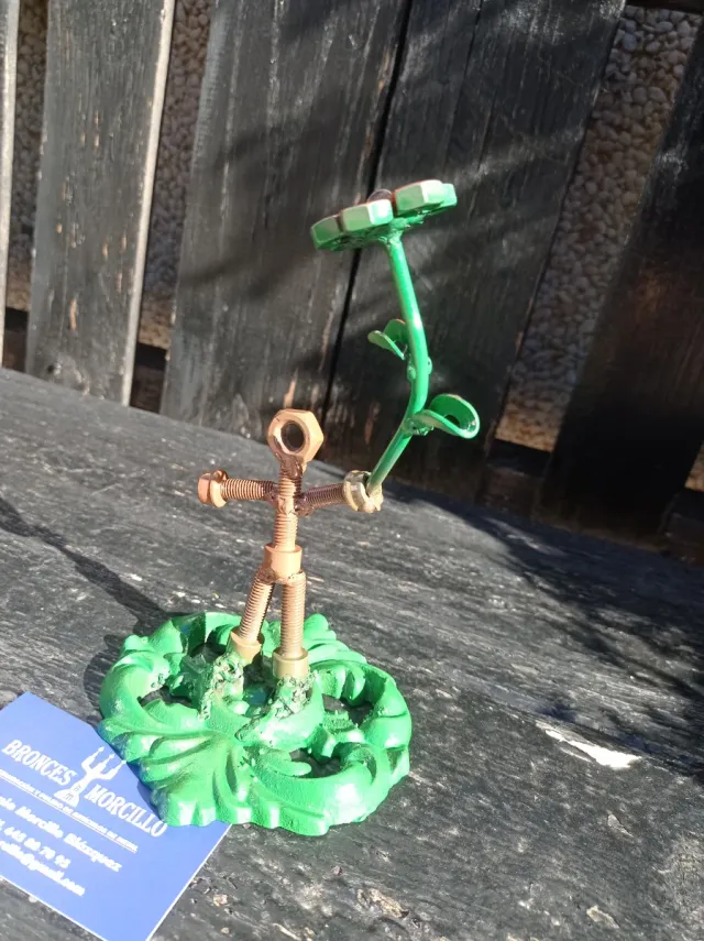 Escultura de metal: chico con flor