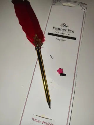 Pluma de escritura roja con detalles dorados