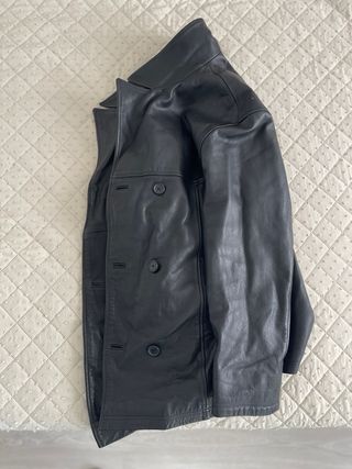 Chaqueta de cuero negra con cierre doble elegante.