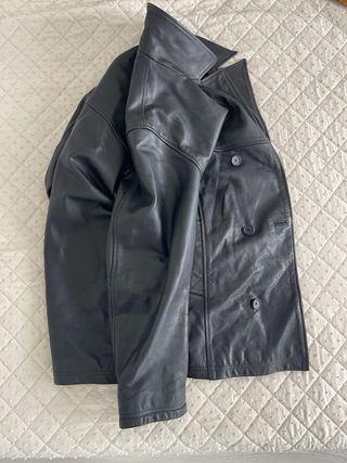 Chaqueta de cuero negra con cierre doble elegante.