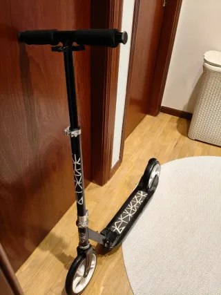 Patinete negro con ruedas blancas