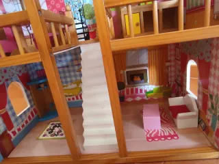 Casa de muñecas rosa con muebles