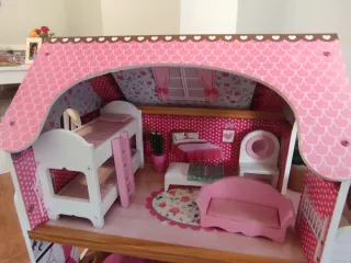 Casa de muñecas rosa con muebles