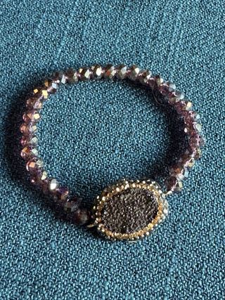 Pulsera plata y cuentas con centro ovalado.