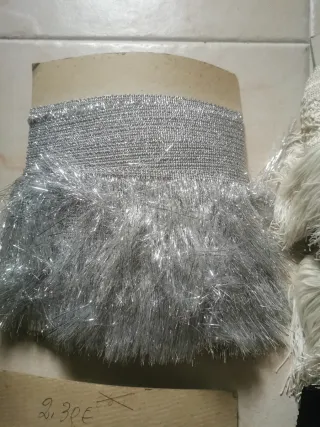 Tiras de flecos de encaje, y de plumas.