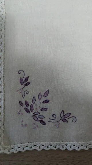 Tappeti in cotone con ricamo floreale viola.