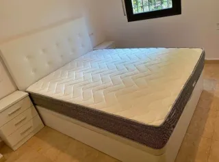 Cama con cabecero tapizado y mesitas