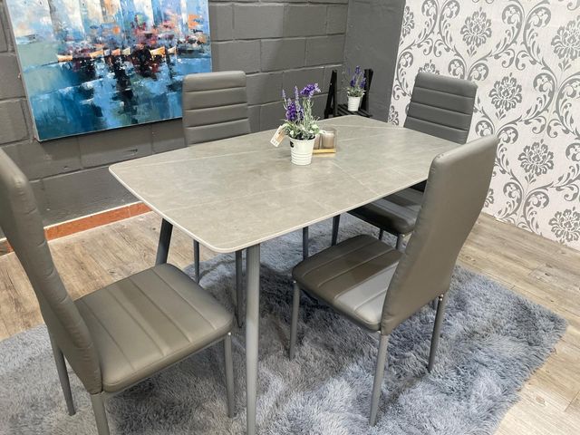 Mesa de comedor gris con 4 sillas acolchadas