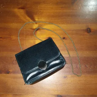 Borsetta nera con tracolla argentata.