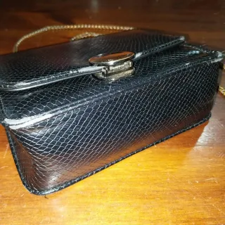 Borsetta nera con tracolla argentata.