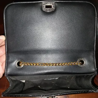 Borsetta nera con tracolla argentata.