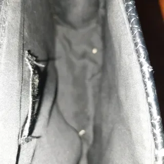 Borsetta nera con tracolla argentata.