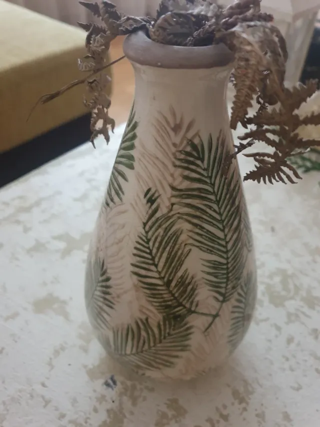 Jarrón de cerámica con hojas verdes