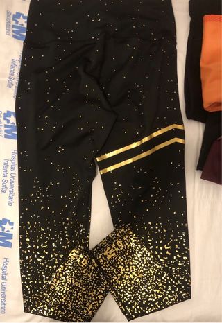 Mallas deportivas negras con detalles dorados