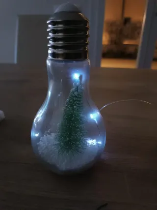 Lampadina decorativa con albero e neve