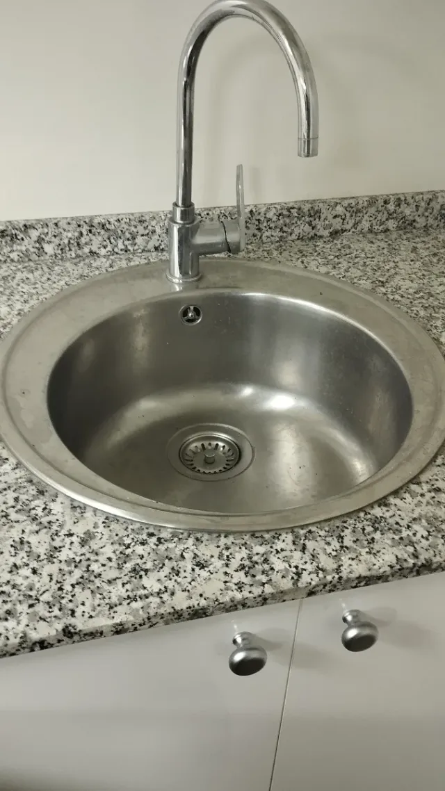 Fregadero redondo metálico con grifo