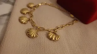 Pulsera dorada con colgantes de concha