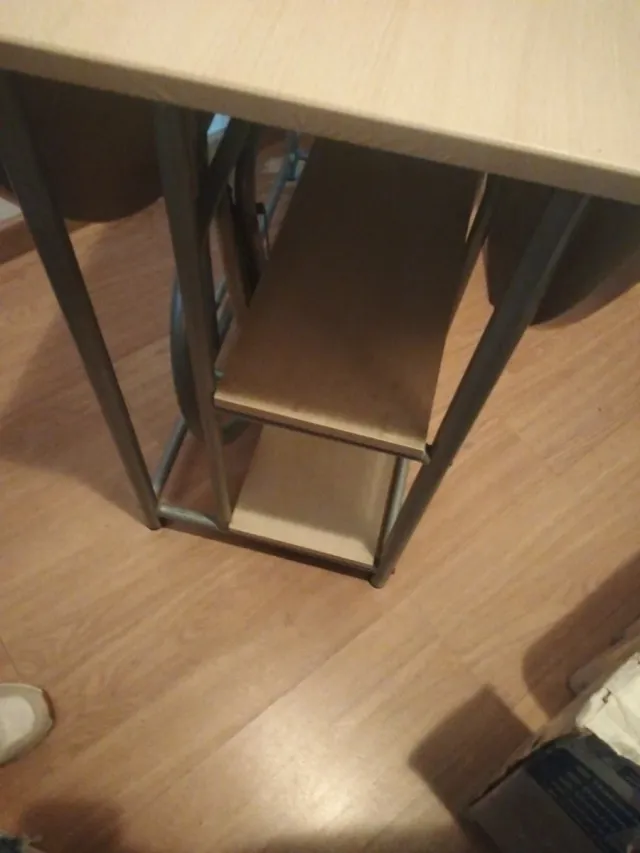 Mesa de cocina con estantes y taburetes