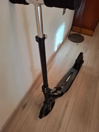 Patinete negro con ruedas rojas