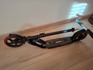 Patinete negro con ruedas rojas