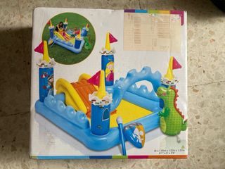 Castillo hinchable con tobogán y dinosaurio