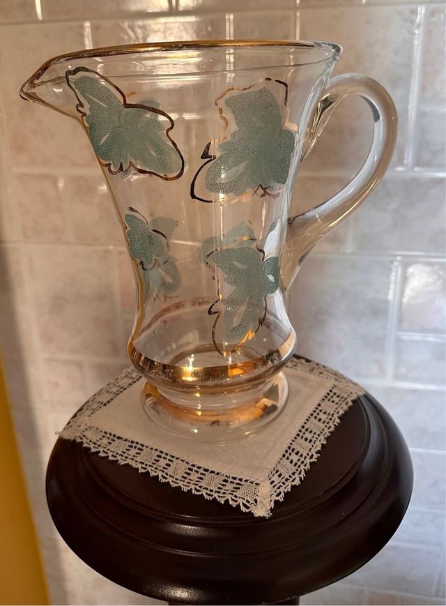 Brocca in vetro vintage con foglie verdi