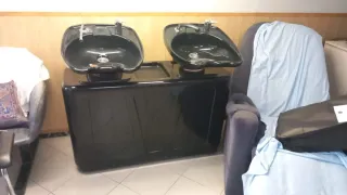 Lavacabezas doble negro y 2 sillas de piel.