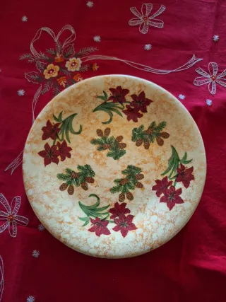 Piatto natalizio decorato con fiori rossi e pigne