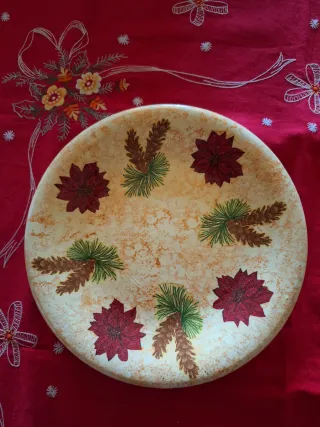 Piatto natalizio decorato con fiori rossi e pigne