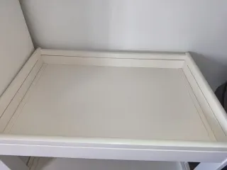 Cambiador de bebé blanco con colchón impermeable.