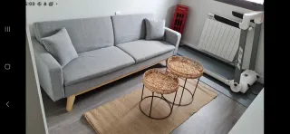 Sofá de tela gris con patas de madera