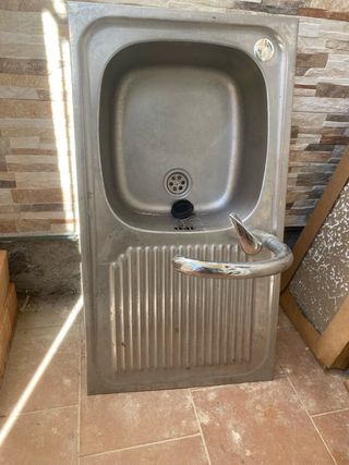 Fregadero de metal plateado con grifo