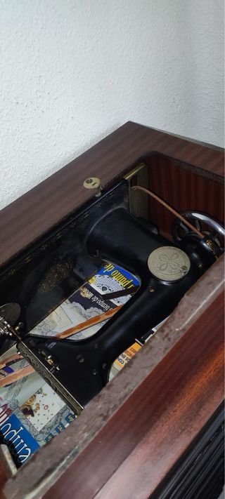 Máquina de coser antigua con mueble.