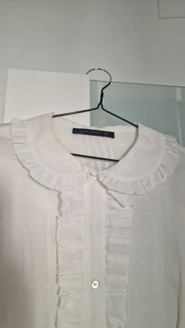 Camisa blanca con volantes y cuello redondo