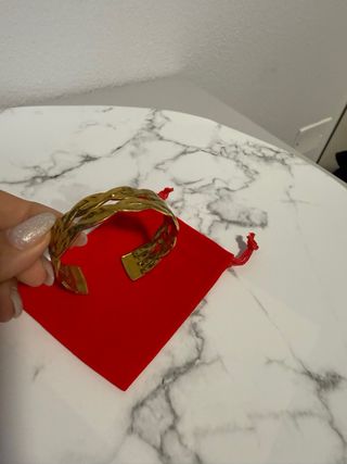 Bracciale rigido dorato intrecciato