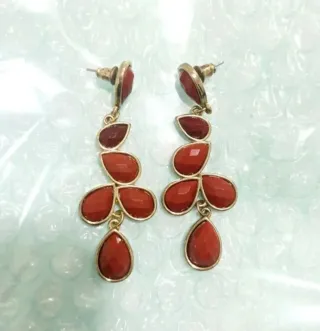 Pendientes largos dorados con piedras rojas