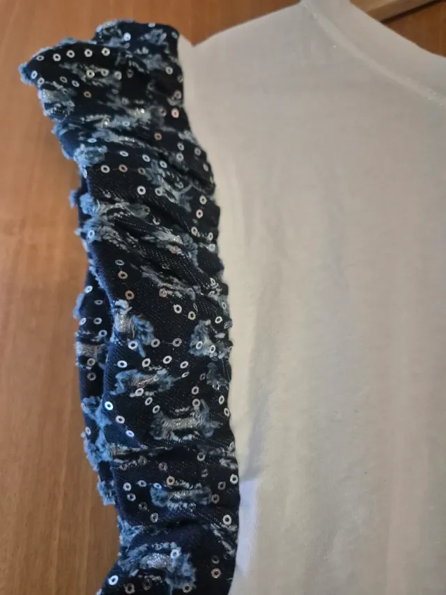 Camiseta blanca con mangas de lentejuelas