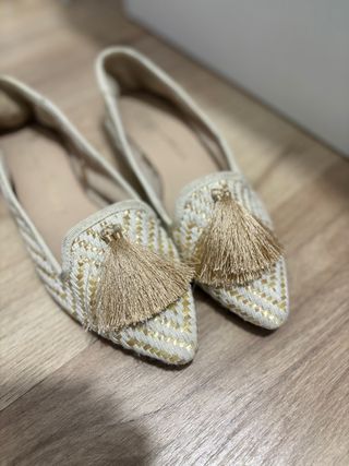 Zapatos planos beige y dorados con flecos
