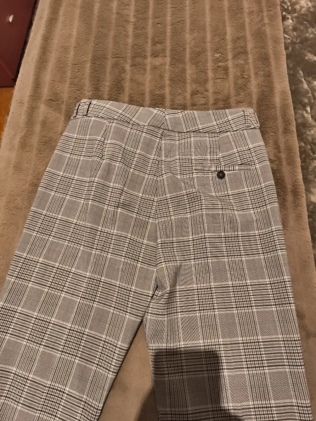 Pantalón de cuadros gris y blanco y azul.