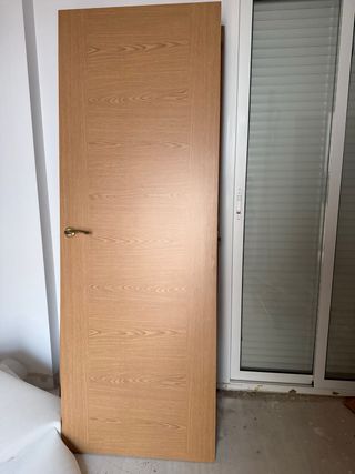 Puerta de madera con manilla dorada