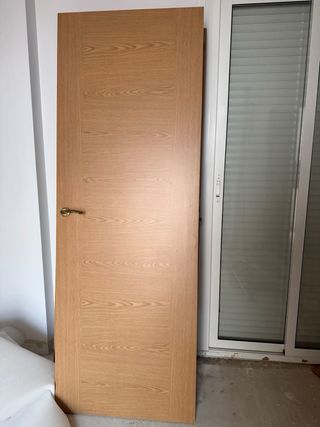 Puerta de madera con manilla dorada