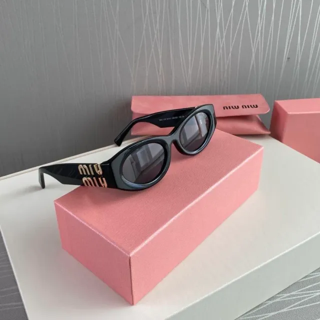 Gafas de sol Miu Miu negras y doradas