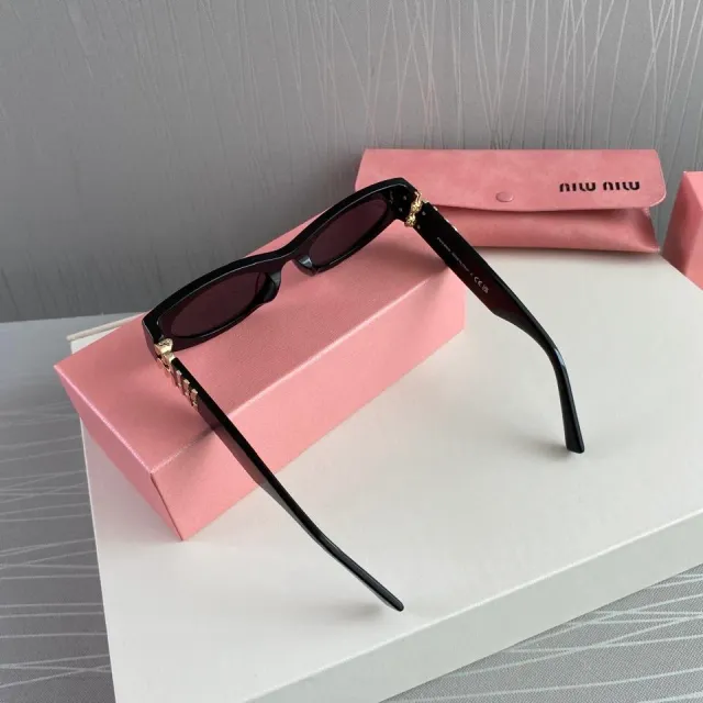 Gafas de sol Miu Miu negras y doradas