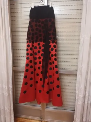 Vestido de fiesta lunares negro y fondo rojo.