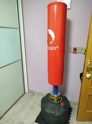 Saco de boxeo de pie rojo con guantes y cuerda.